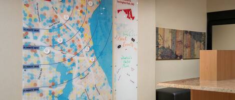 A reception area with a map on the wall, a bulletin board with handwritten notes, and a wooden counter.