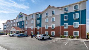 A multi-story hotel with a mix of brick and painted exteriors, featuring a central entrance with a red roof. - Extended Stay America Select Suites - Phoenix - North (Phoenix)