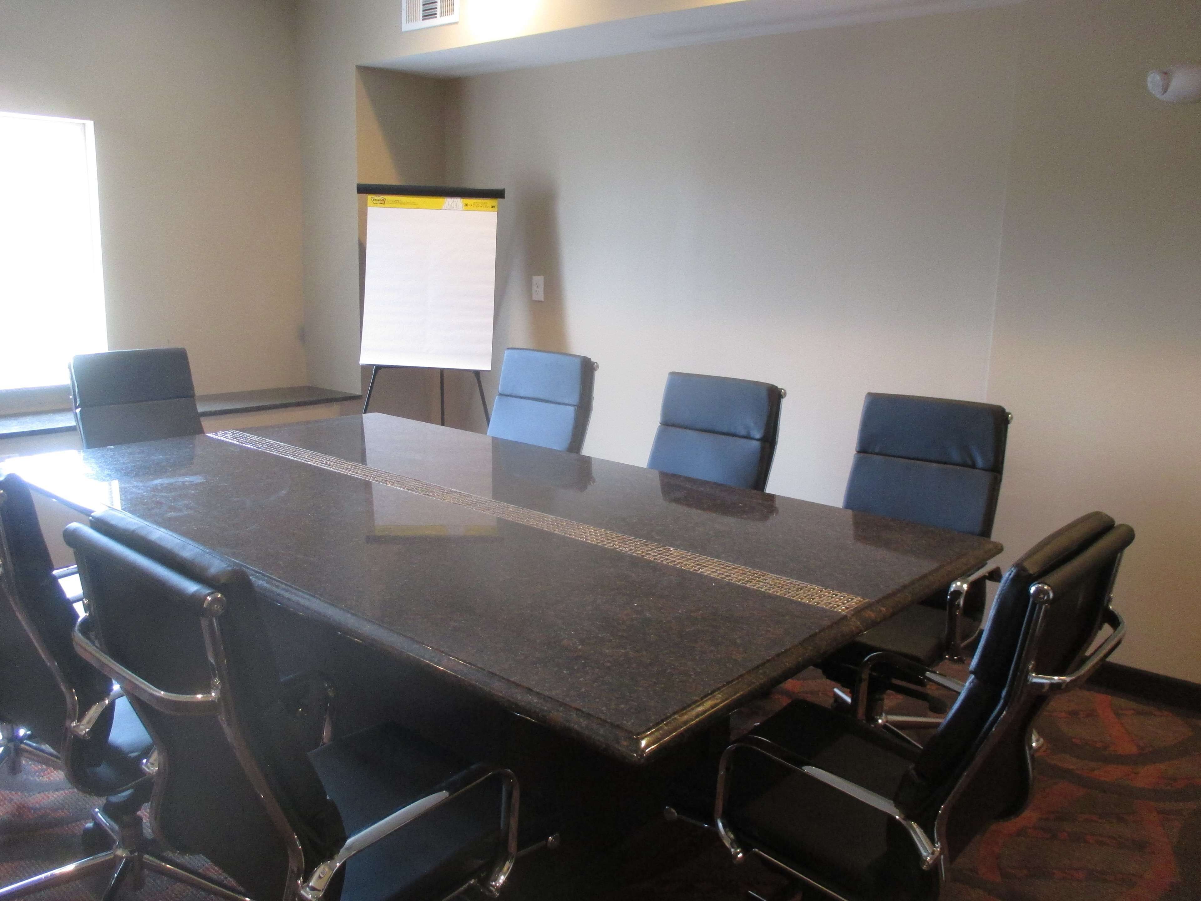 A conference room with a long table and six chairs.