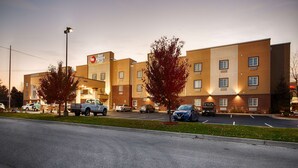 Un hotel Best Western Plus con fachada de ladrillo, múltiples ventanas y un estacionamiento con varios coches.
