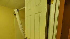 Un baño con una puerta blanca, una bañera y un cortinero de ducha.