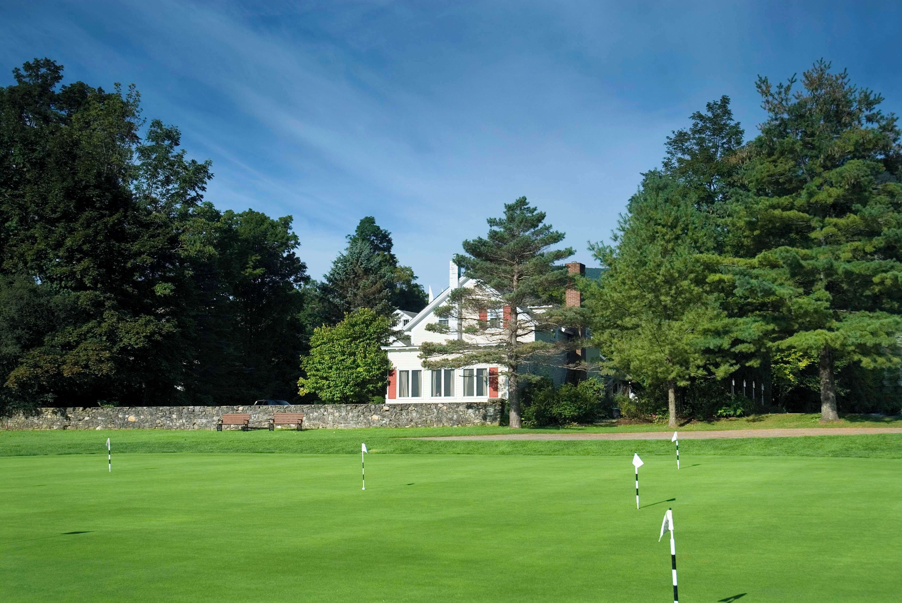 A golf course with a house in the background.