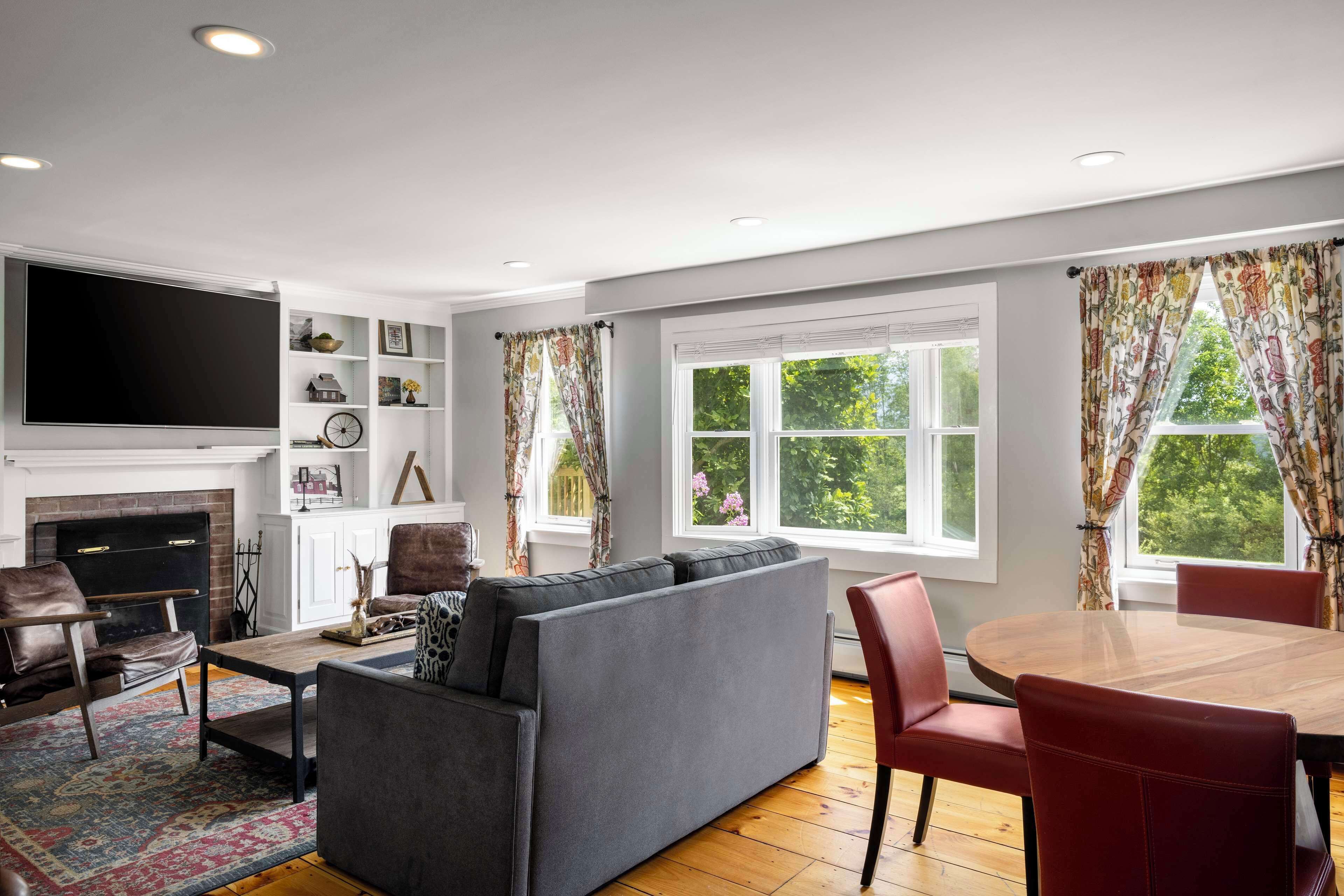 A living room with a fireplace, a sofa, a coffee table, and a TV.