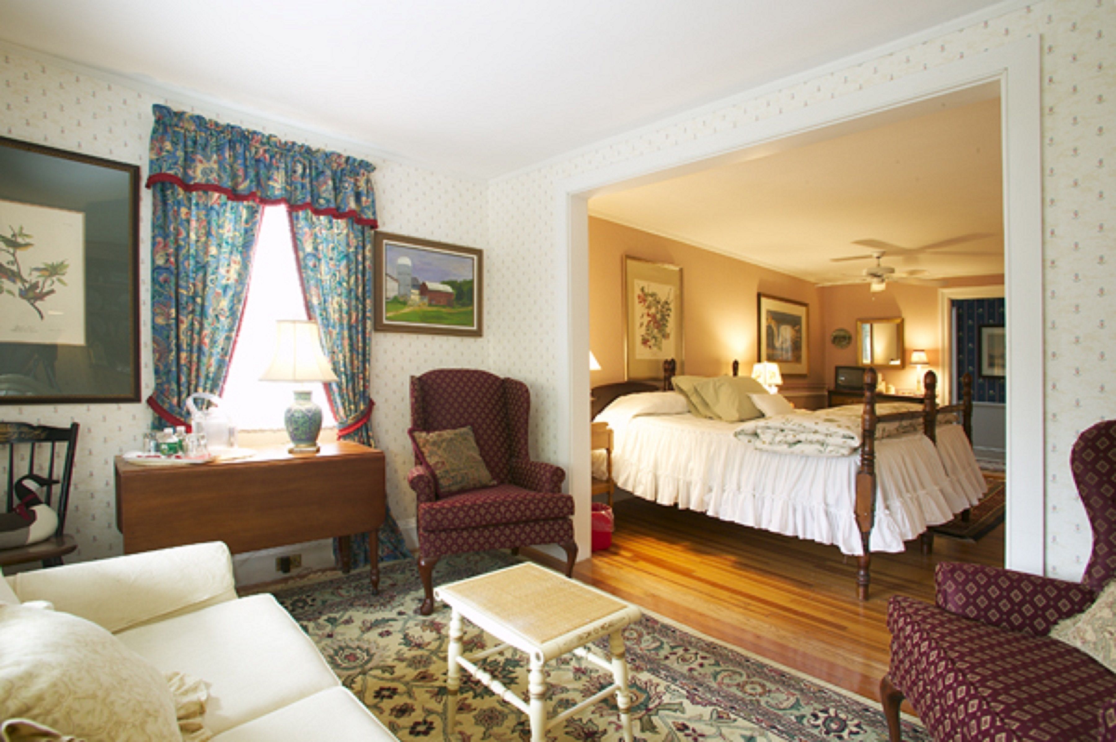 Une chambre confortable avec un lit, une chaise, une petite table et une table de chevet.