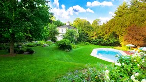 A well-maintained garden with a swimming pool, surrounded by lush greenery and a white building. - The Stockbridge Country Inn Closest B&B to Norman Rockwell Museum and Chesterwood (Stockbridge)