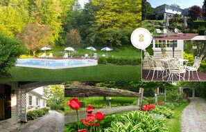 A pool area with lounge chairs and umbrellas, a garden with red tulips, and a house with a porch.