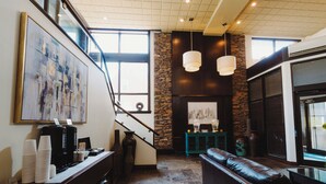Un intérieur moderne avec un escalier, une cheminée et un coin salon.