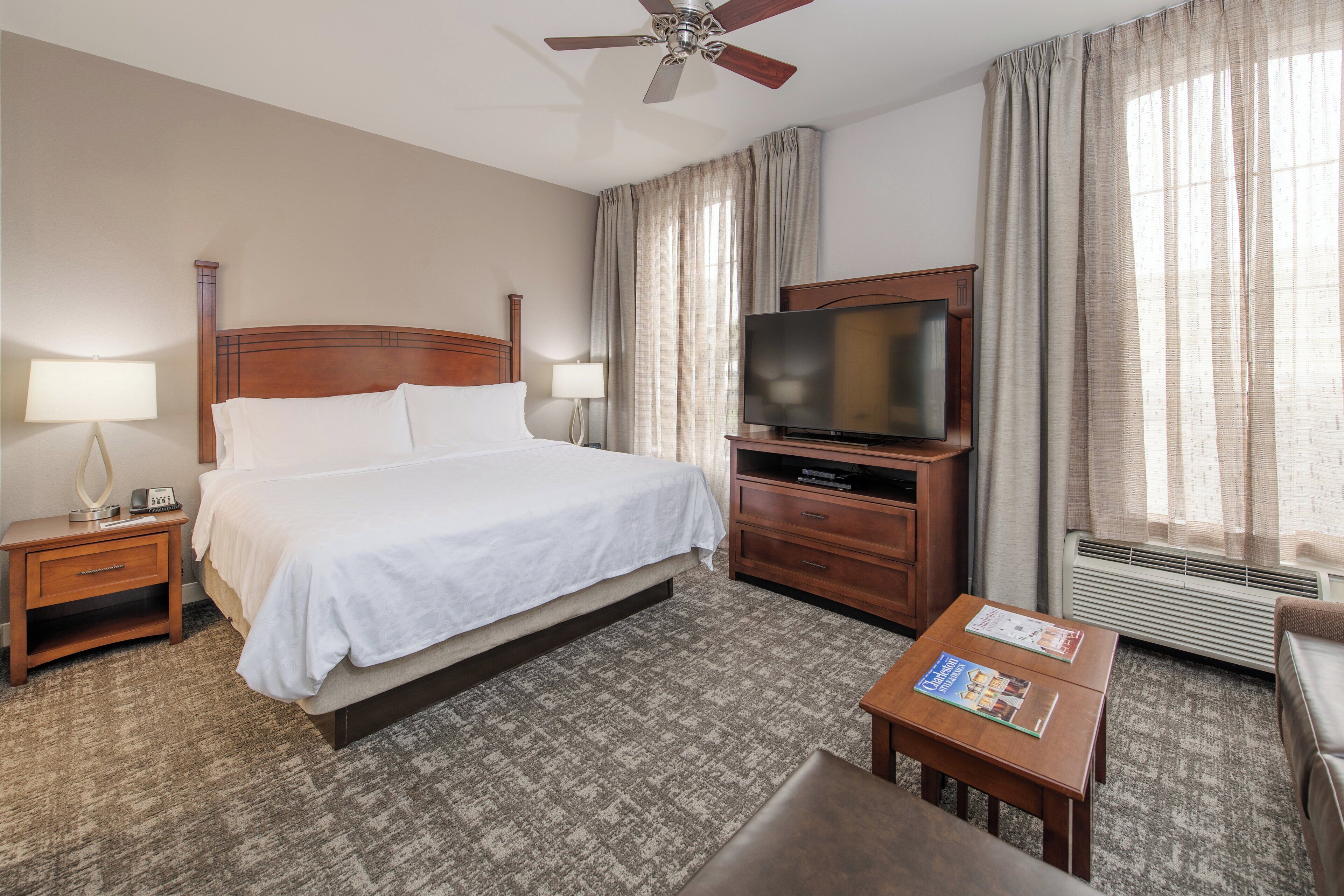 A hotel room with a bed, a television, a desk, and a chair.