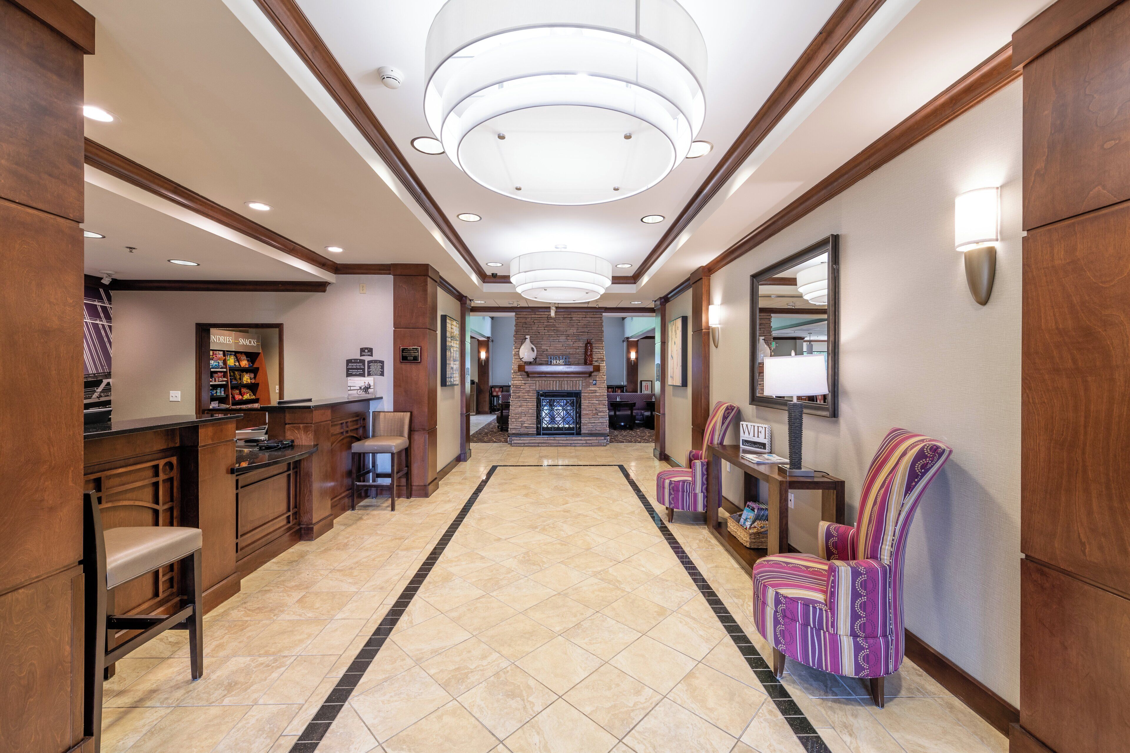 A hotel lobby with a reception desk, seating area, and a fireplace.