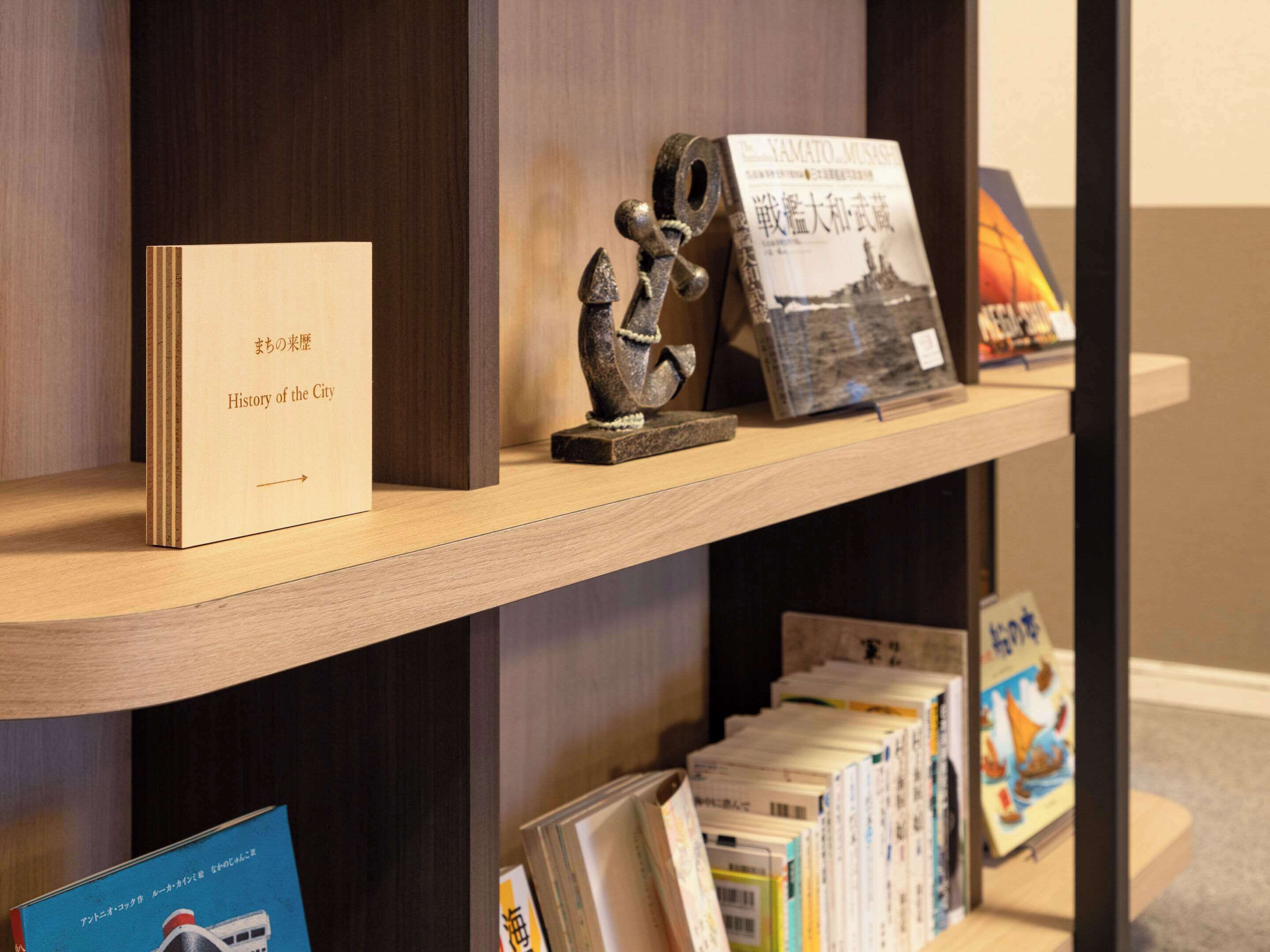 A wooden shelf with books and a small statue.