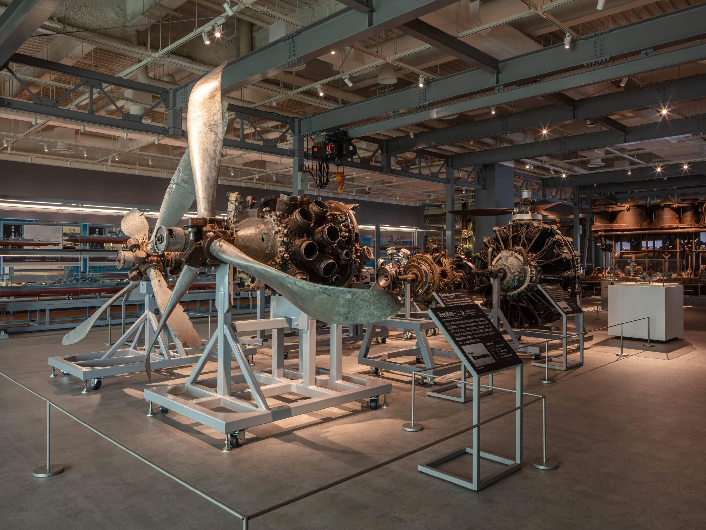 A large industrial space with machinery on display, metal structures, and a high ceiling with visible beams.