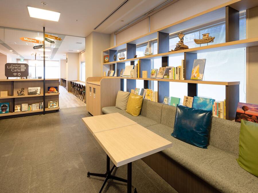 Un café en una biblioteca con un sofá, estanterías y una mesa.