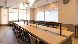 A conference room with a long table, chairs, ceiling lights, windows, and a clock on the wall. - Comfort Hotel Kure (Kure)