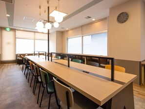 A conference room with a long table, chairs, ceiling lights, windows, and a clock on the wall. - Comfort Hotel Kure (Kure)