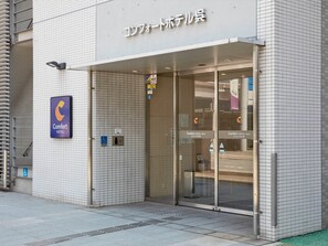 A hotel entrance with a sign for Comfort Hotel, an AED symbol, and a wheelchair accessibility sign. - Comfort Hotel Kure (Kure)
