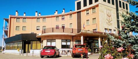 A hotel with a curved facade, a balcony, and a sign indicating it is a hotel.