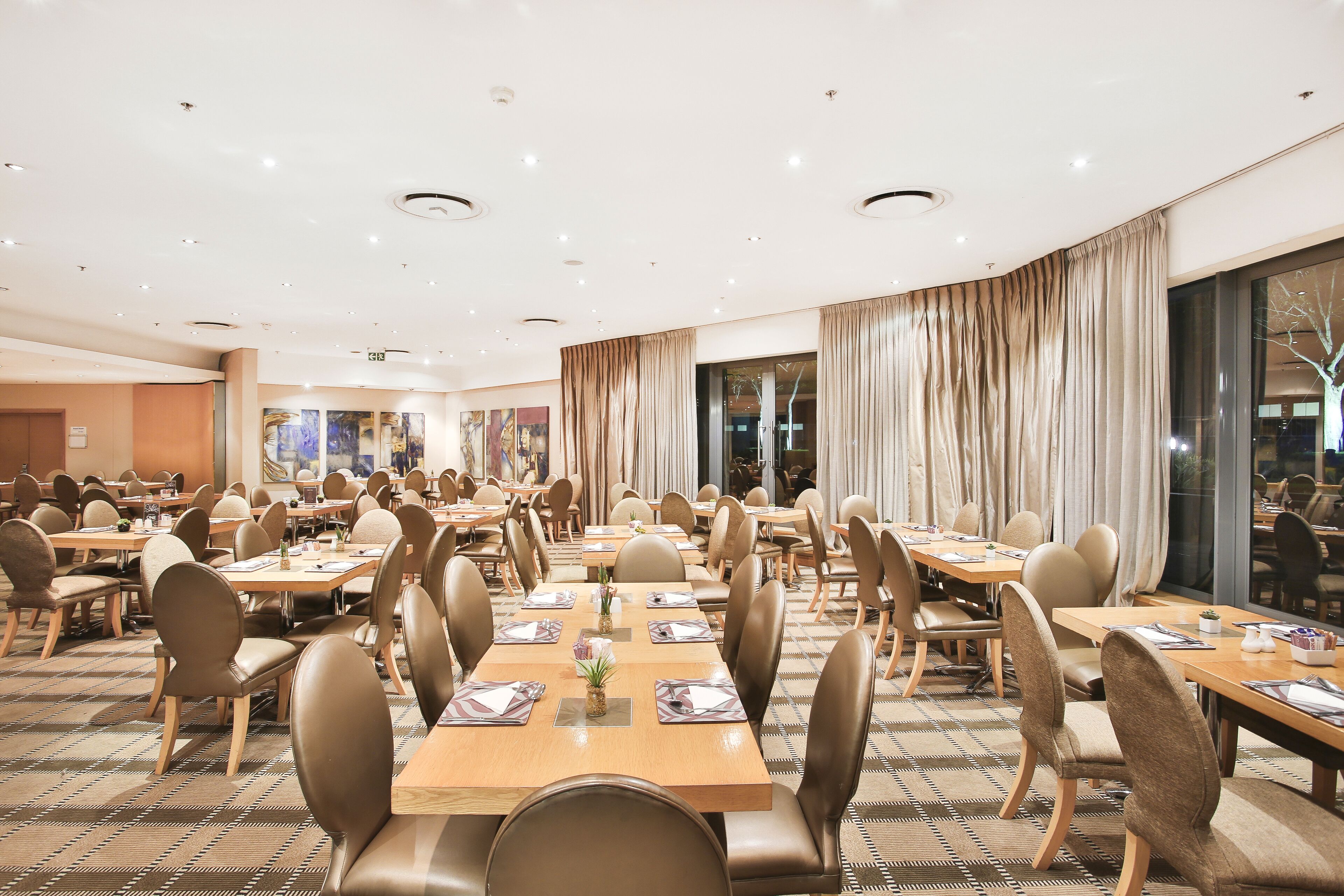 Une grande salle à manger avec de nombreuses tables et chaises, disposées dans un espace bien aménagé.