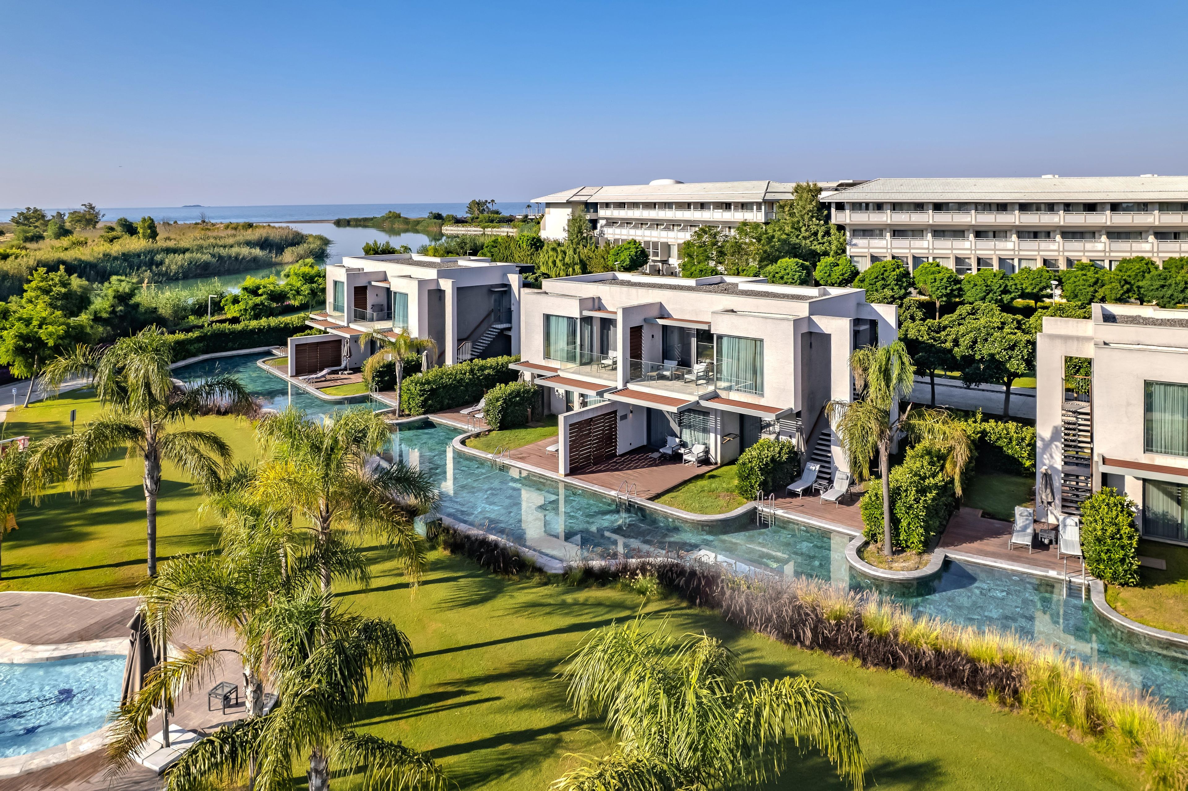 Ein modernes Resort mit Pool, mehreren Gästezimmern und Blick auf den Ozean.