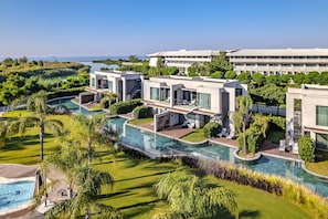 Una moderna struttura ricettiva con piscina, diverse camere e vista sull'oceano.