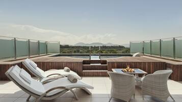 Eine Dachterrasse mit Pool, Liegestühlen und Esstisch.