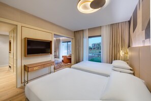 Une chambre d’hôtel avec un lit, une télévision, un bureau et une vue sur l’extérieur.