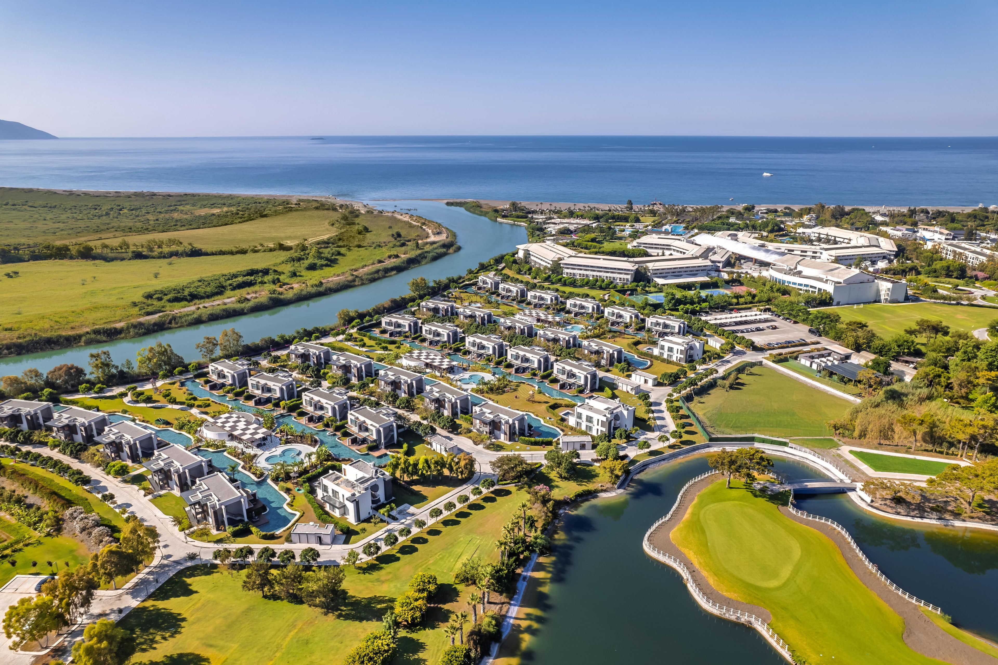 Ein Resort mit mehreren Gebäuden, einem Golfplatz und einem Fluss.
