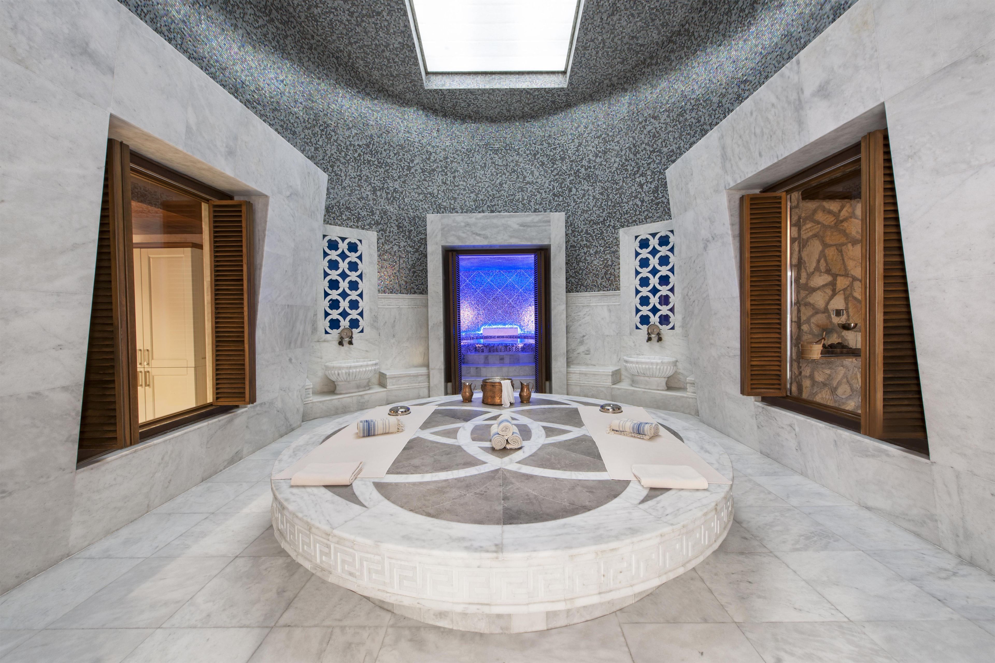 A spa room with a circular seating area, a central fountain, and a skylight ceiling.