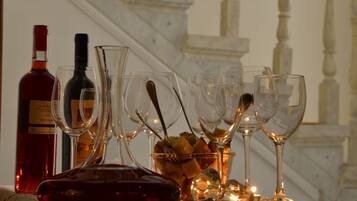 A table with wine bottles and glasses, a bowl of bread, and a candle.