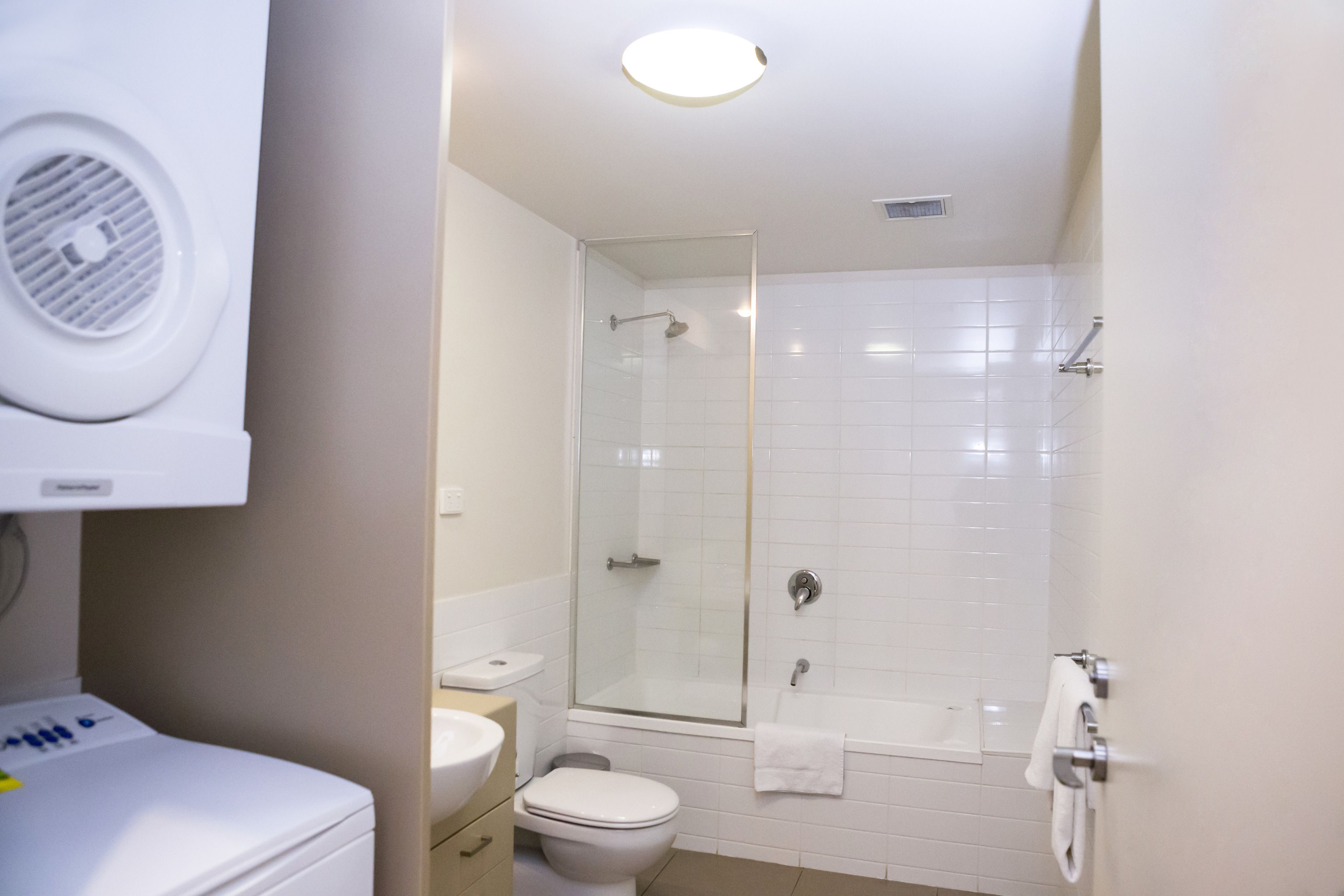 Une salle de bain moderne équipée de toilettes, d’un lavabo et d’une douche à parois de verre.