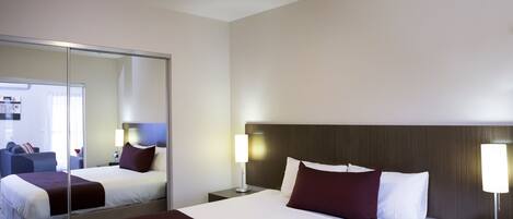 Habitación de hotel con una cama grande, mesitas de noche, un espejo y vistas al interior de la habitación.