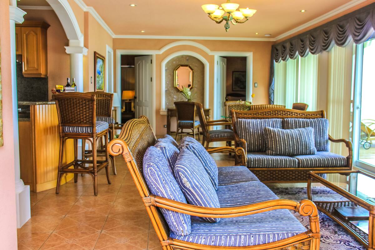 Amplia sala de estar con un sofá grande, sillones y una zona de comedor.