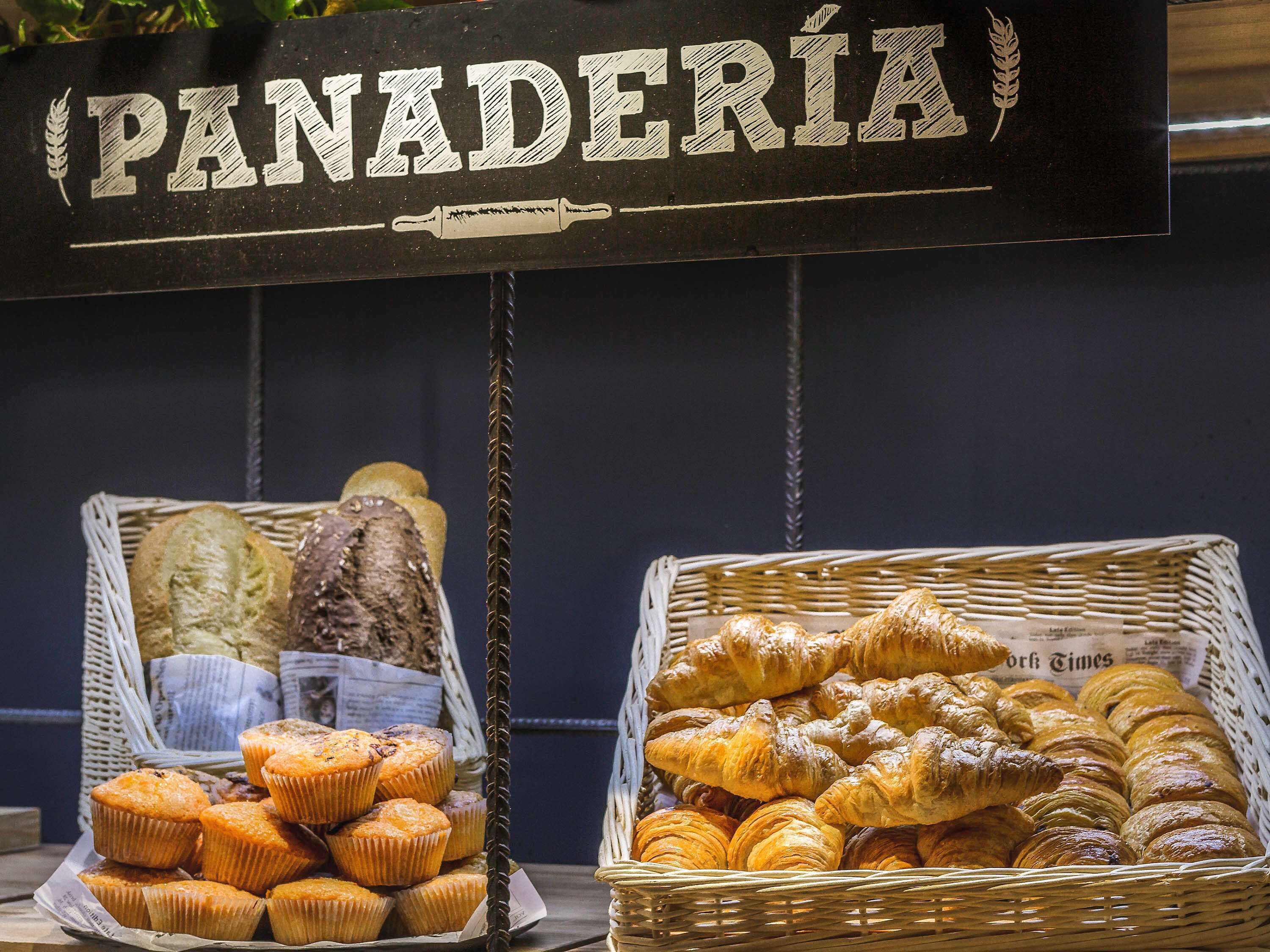 A bakery display with a sign reading "PANADERÍA" and baskets of baked goods.