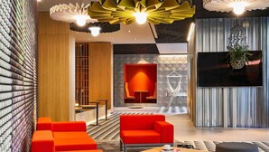 Ein modernes Interieur mit einem roten Sofagarnitur, einem Couchtisch und einer Hängelampe.
