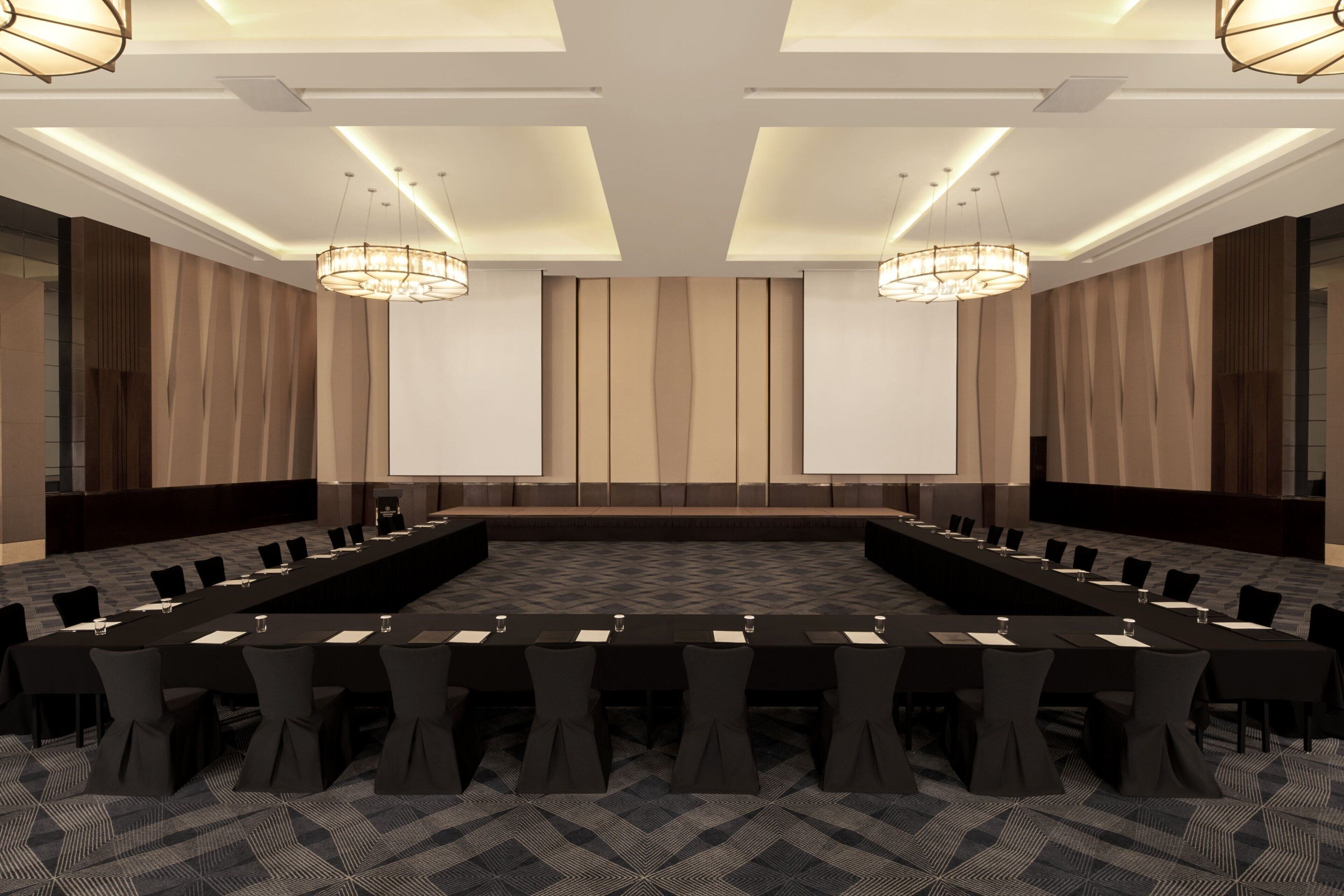Une salle de conférence équipée d’une longue table, de chaises et d’un écran de projection.
