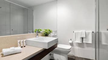 A modern bathroom with a large sink, toilet, and shower area.