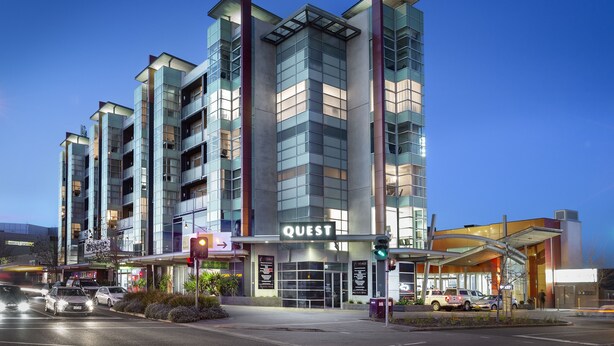A modern hotel with a prominent 'QUEST' sign, multiple floors, and a glass facade. - Quest Caroline Springs (Caroline Springs)