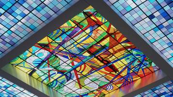 A stained glass window with geometric patterns and a central circular design.