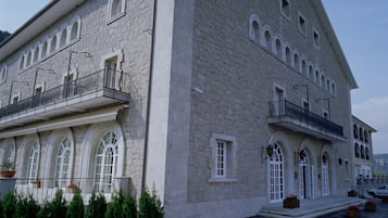 Un edificio grande de piedra con ventanas y balcones de arco, probablemente un hotel o edificio público.