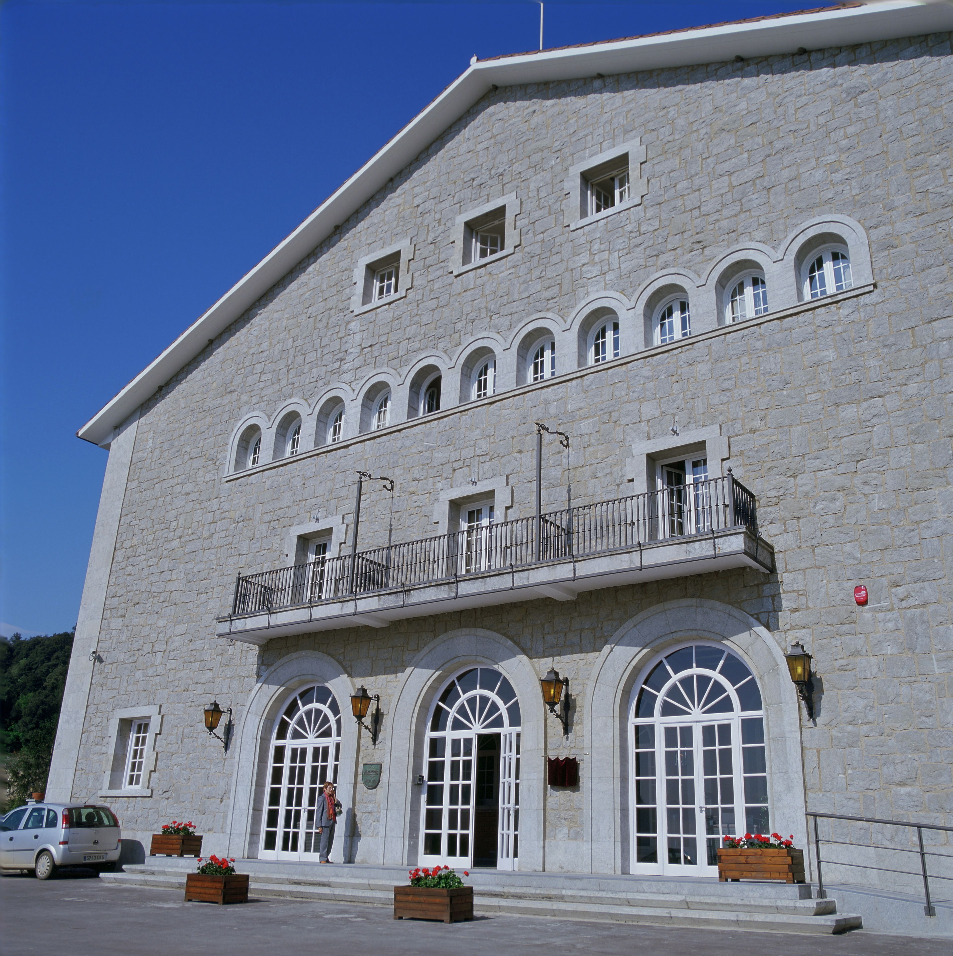 Un edificio de piedra grande con varias ventanas arqueadas y un balcón.