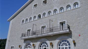 Un edificio de piedra grande con varias ventanas arqueadas y un balcón.