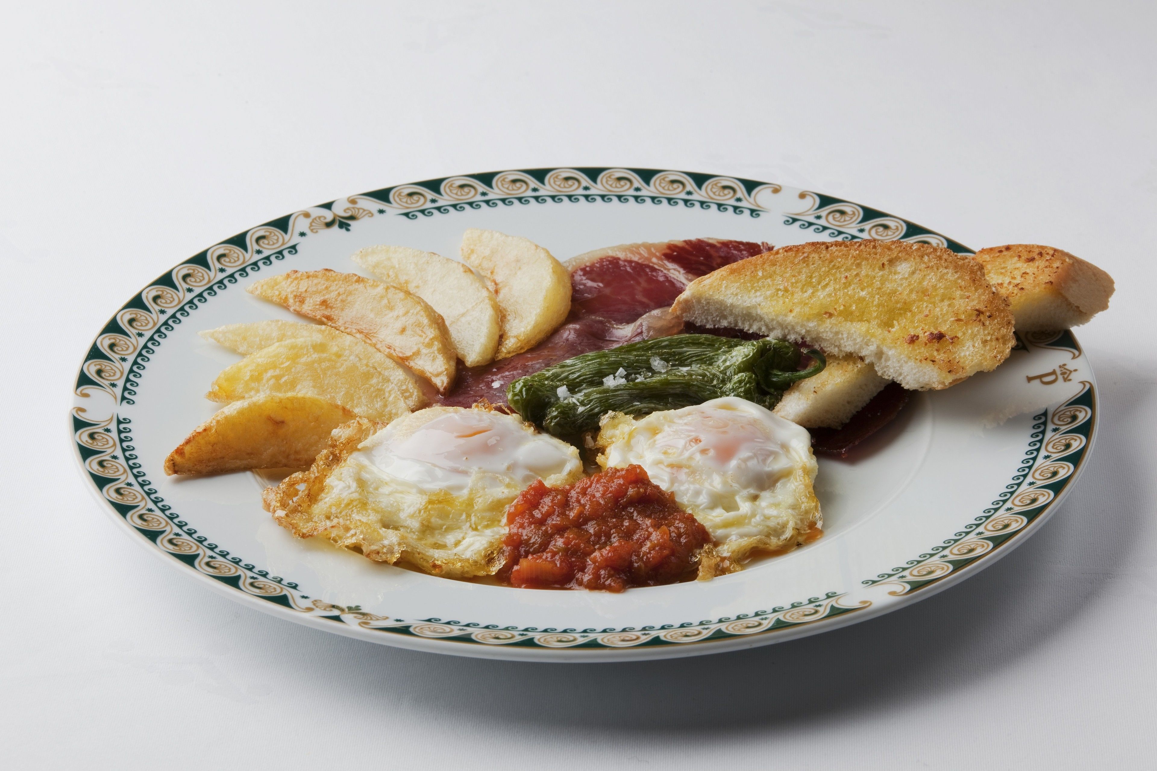 A plate with eggs, bread, and vegetables.