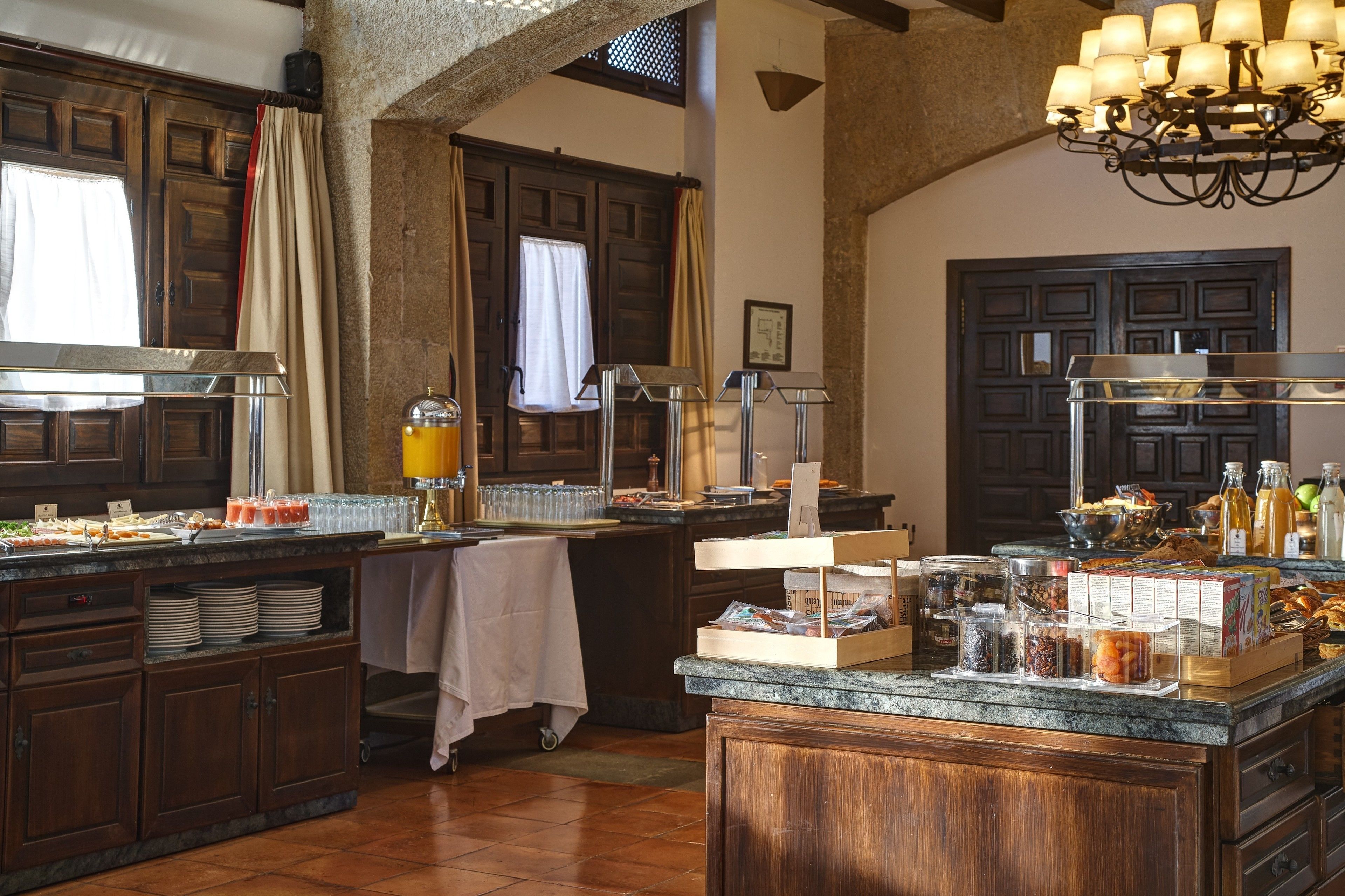 Una cocina con armarios de madera, encimera de granito y diversos alimentos.