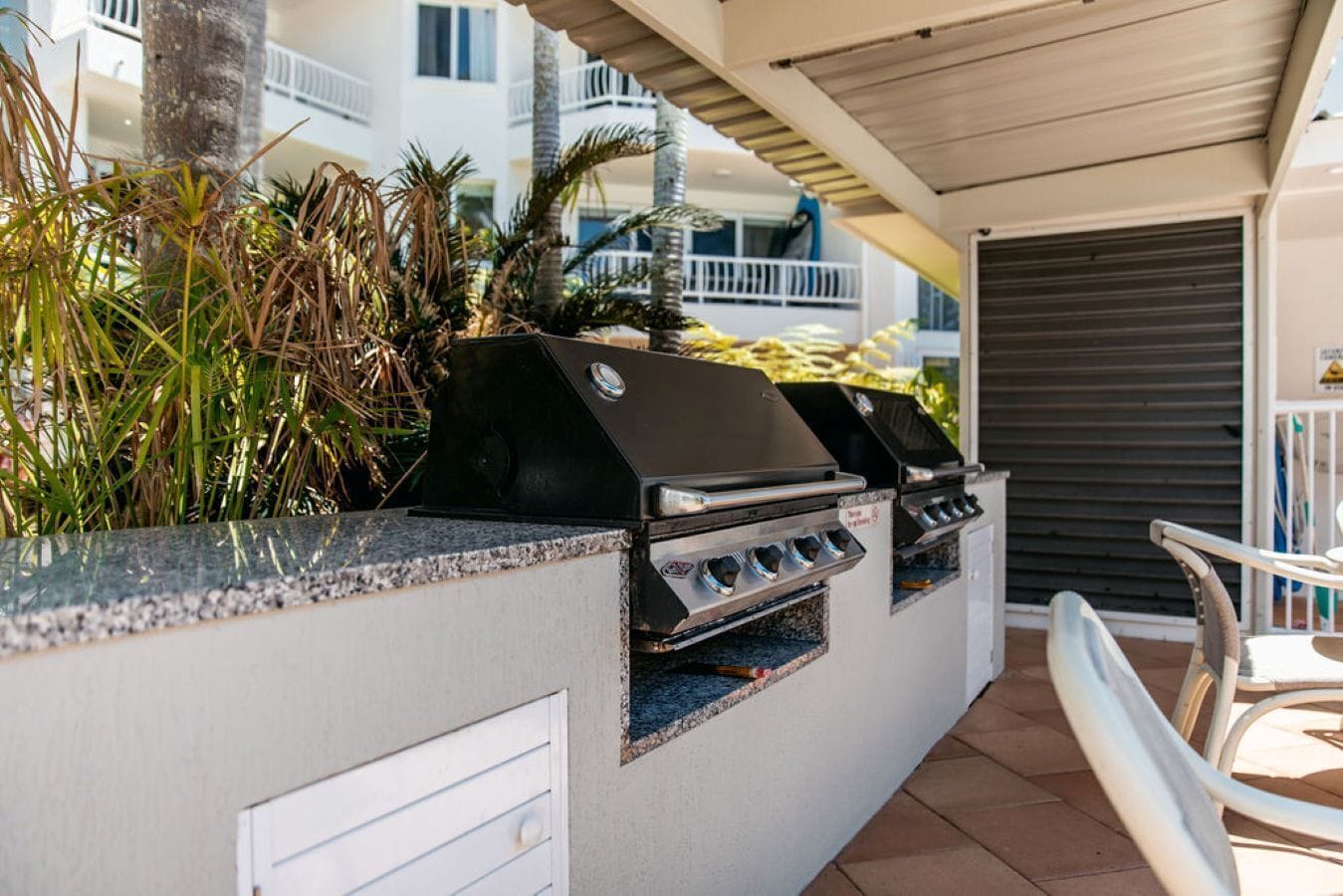 Un espace bar extérieur avec un barbecue et des sièges.
