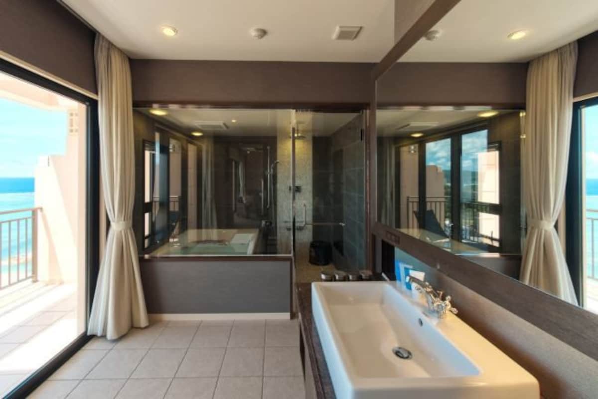 Un baño moderno con un espejo grande, una bañera y un lavabo.