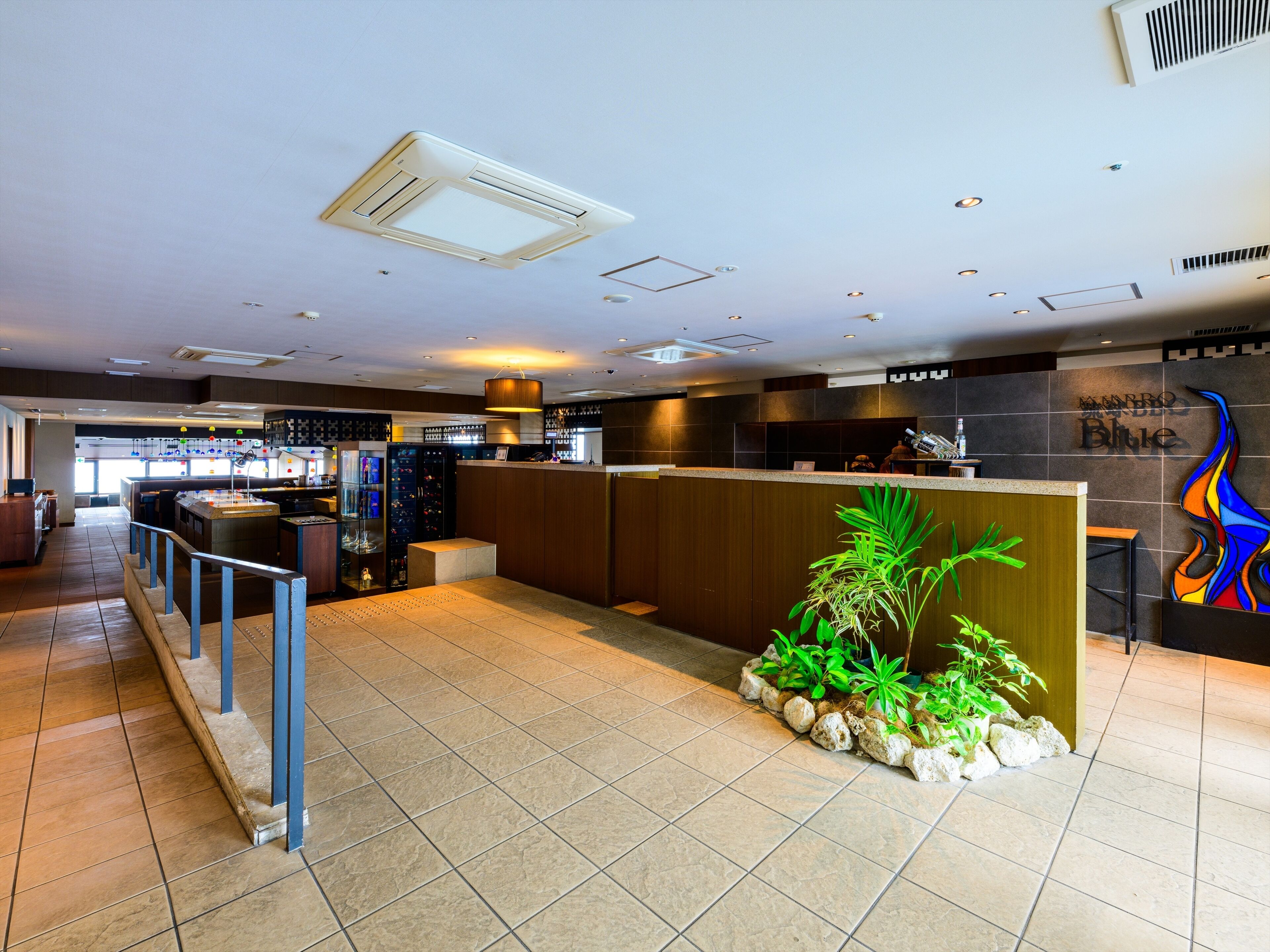 Eine moderne Hotelhalle mit einer Rezeption, einer Bar und einer Sitzecke.
