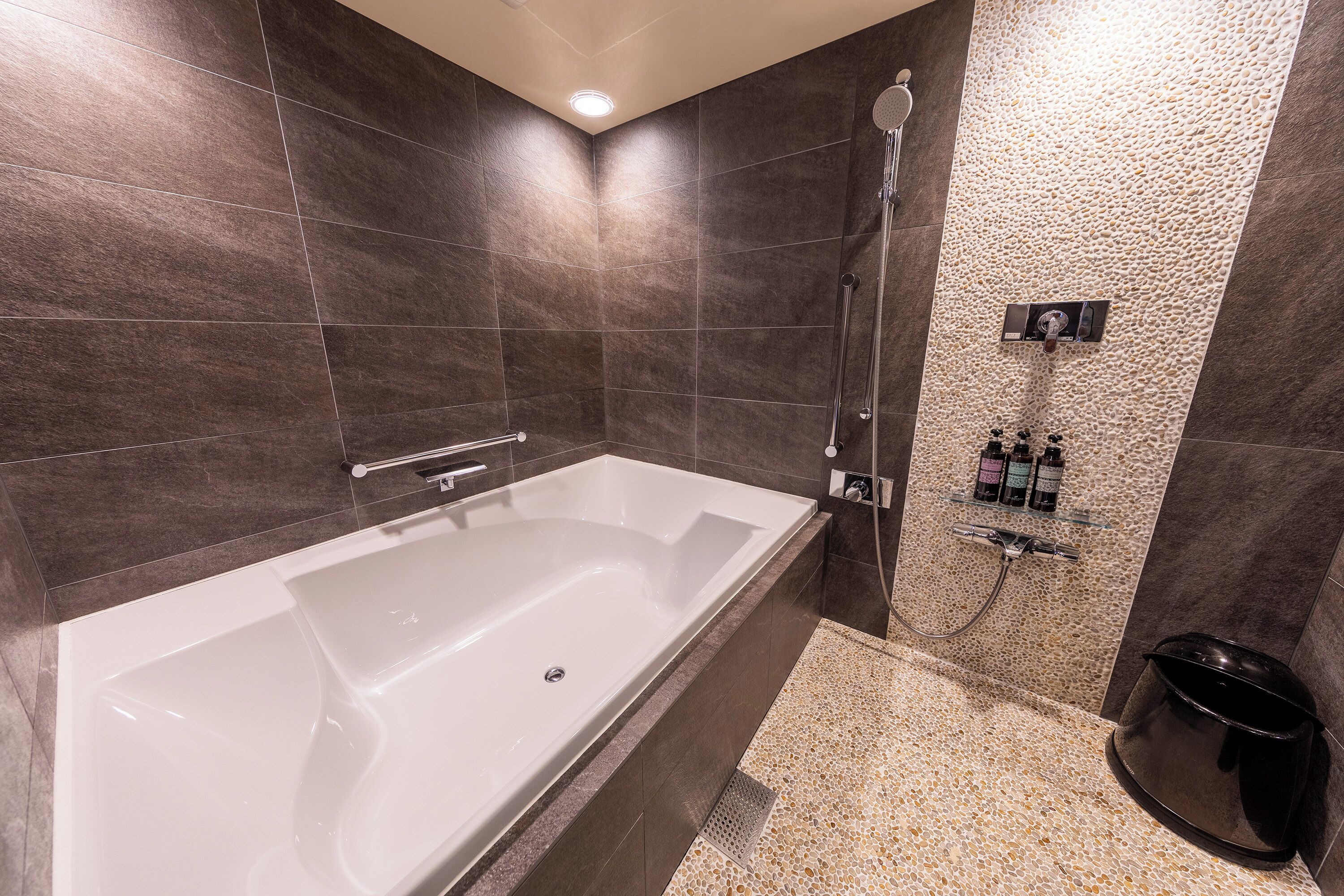 Un baño moderno con una bañera grande, zona de ducha y encimera de granito.