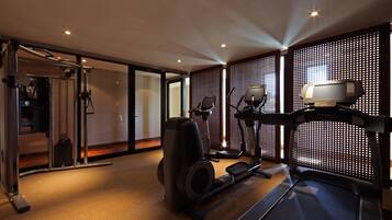 A modern gym with cardio equipment, a mirror, and a treadmill.
