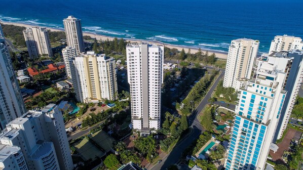 Un hôtel de grande hauteur, avec de nombreux étages, une piscine et une vue sur la plage.