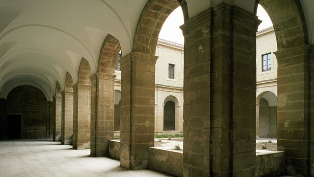 A spacious interior with high ceilings and arched stone columns. - Parador de Santo Domingo Bernardo de Fresneda (Santo Domingo de la Calzada)