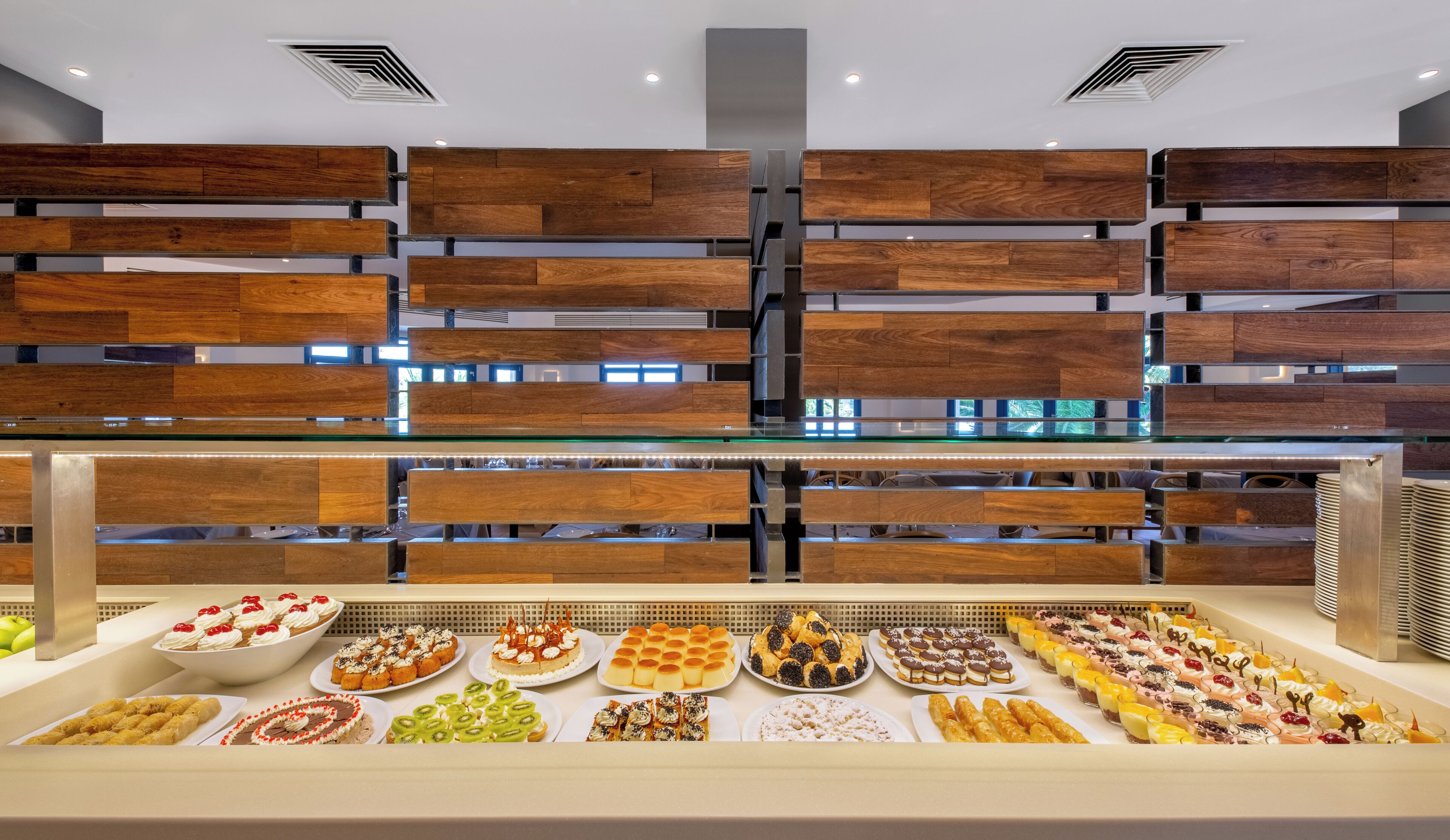 Un espace buffet agrémenté de lambris en bois et proposant une grande variété de desserts.